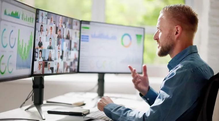 Tech employee reviews data across multiple monitors to present research findings on a video call that's seamlessly connected with fiber internet